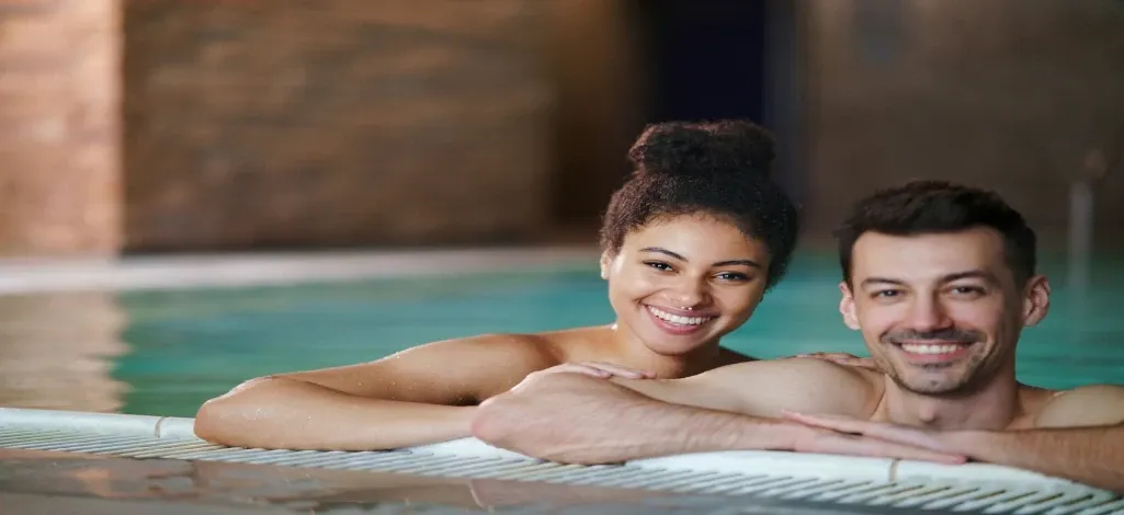 Two people enjoy spending time at the enclosed hot springs near Canmore.