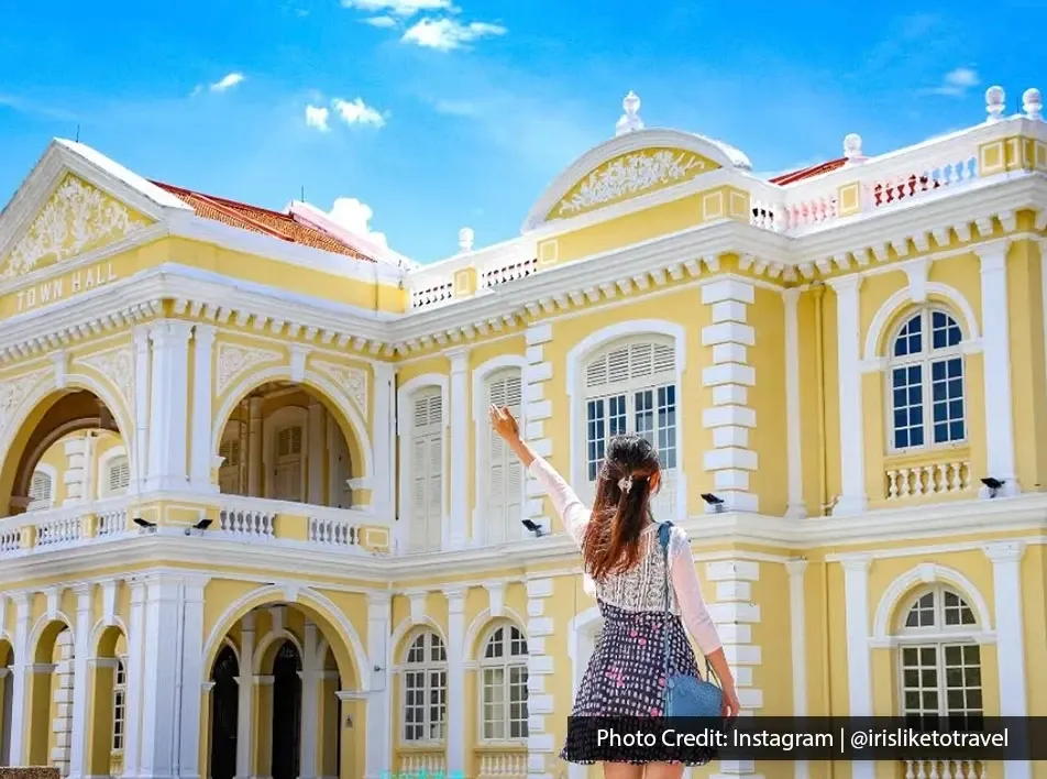 Tourist standing in front of Penang Town Hall historic architecture.
