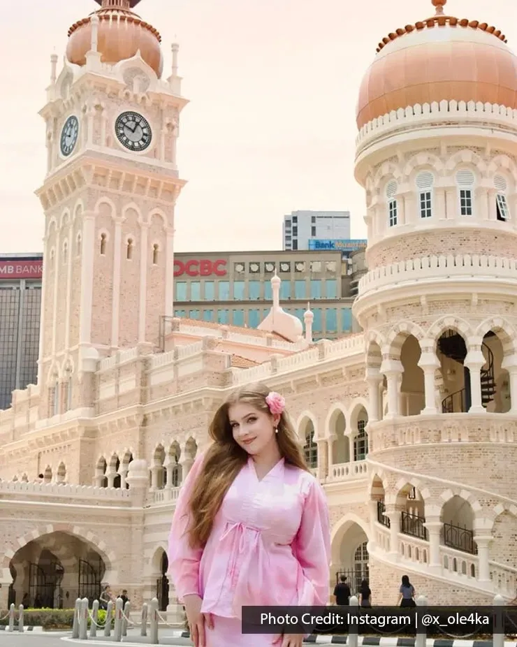 Visitor standing beside Sultan Abdul Samad Building clock tower