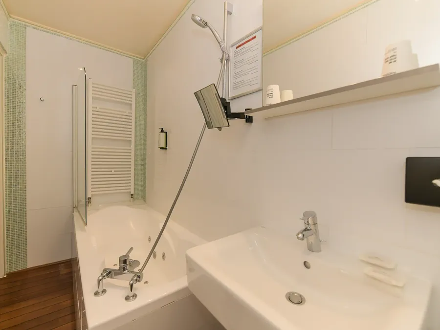Salle de bain élégante avec baignoire et lavabo à l'Hôtel Villa Aultia à Ault.