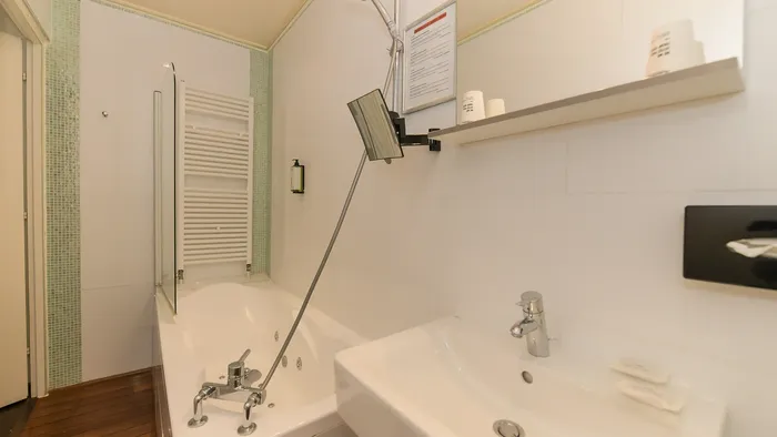 Salle de bain avec baignoire et lavabo à l'Hôtel Villa Aultia.