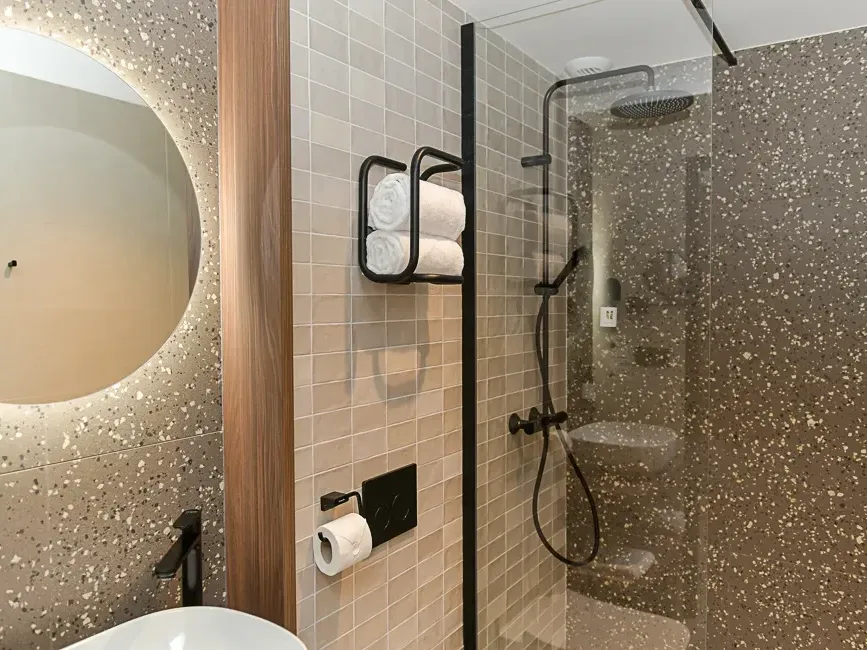 Salle de bains moderne avec douche et lavabo dans la Chambre Comfort à Hôtel Rivella Clisson.