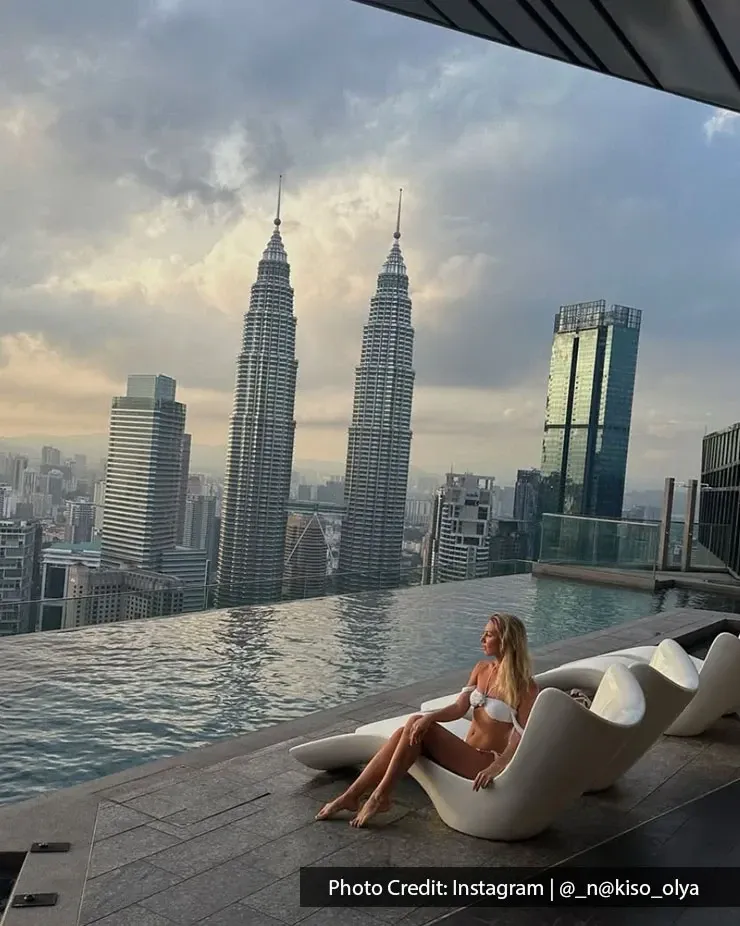 Guest enjoying a rooftop pool experience with Petronas Twin Towers view at Imperial Lexis Kuala Lumpur.