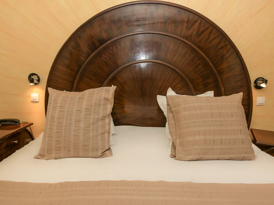 Lit avec tête de lit en bois et oreillers à l'Hôtel Villa Aultia à Ault.