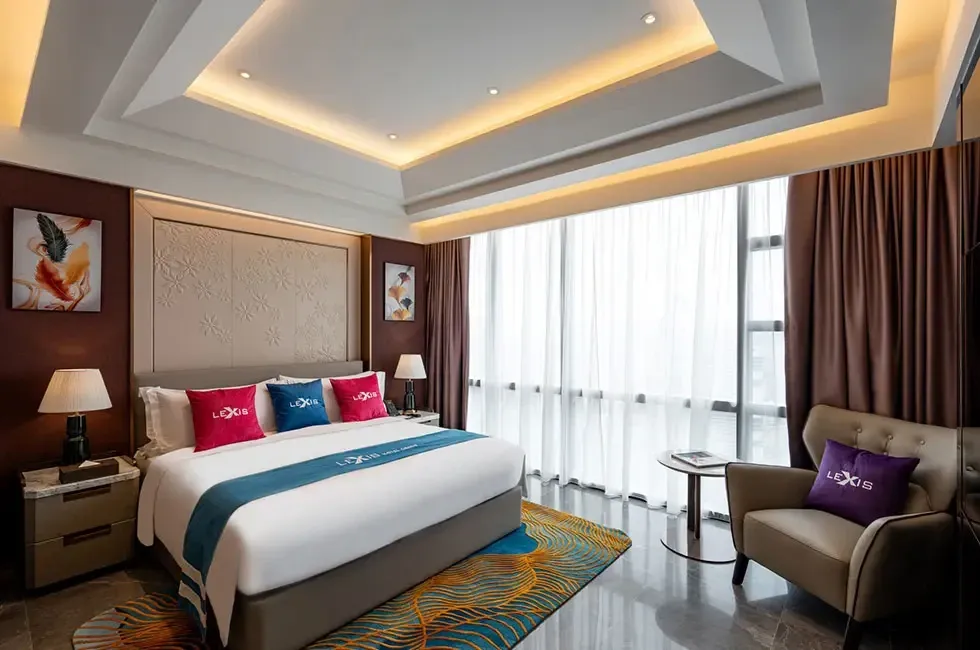 One king bed with colourful throw pillows in the Imperial Pool Suite - Imperial Lexis Kuala Lumpur