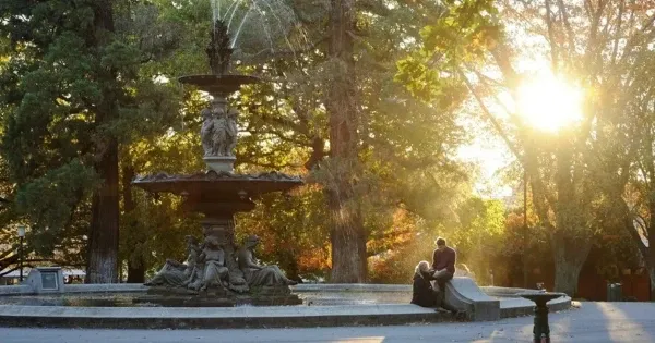 A couple sit together alongside a fountain at Prince’s Square