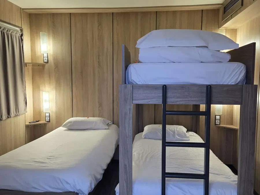 Chambre familiale triple avec lits superposés et décoration en bois au Hôtel Aurillac Aéroport à Aurillac.