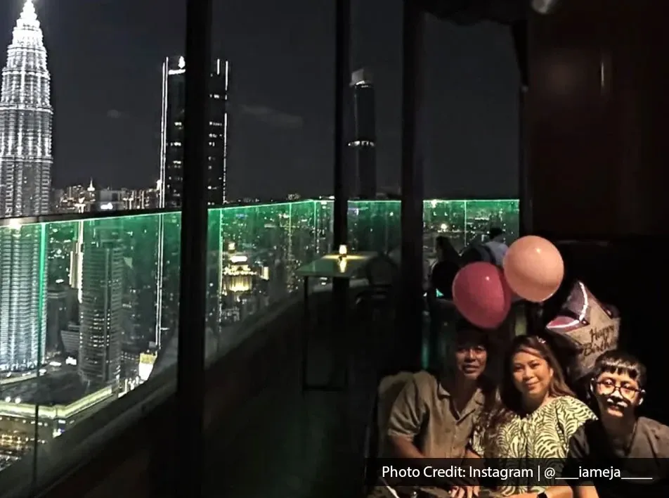 A family photo with birthday balloons, featuring a night view of KL city skyline.