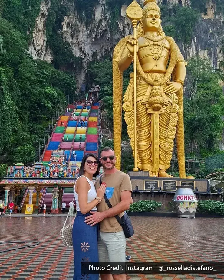 Couple posing beside the Lord Murugan statue at Batu Caves