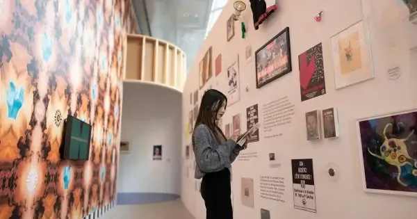 Woman wanders thoughtfully through an Auckland art gallery