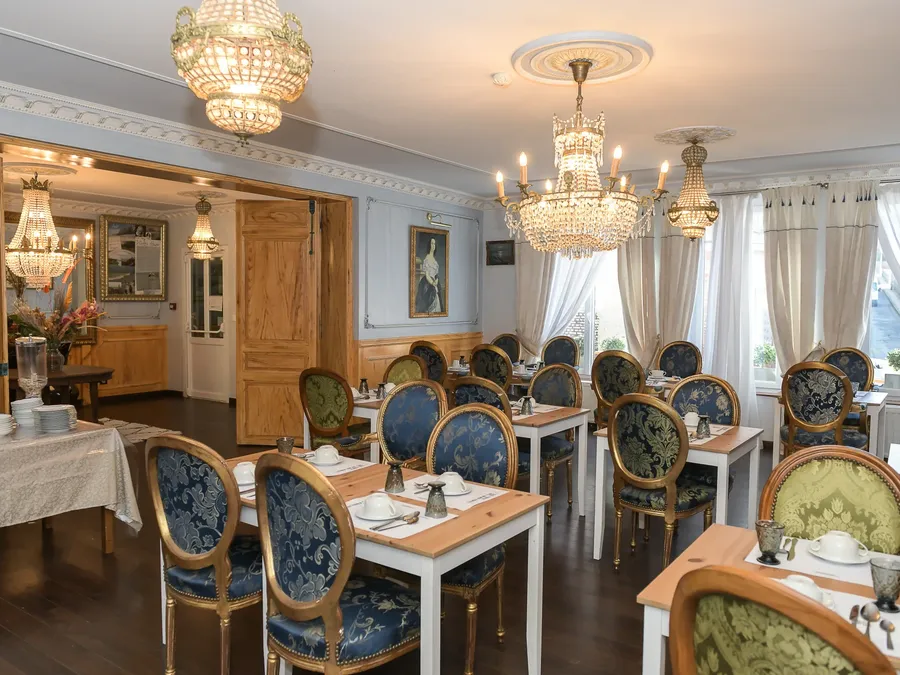 Salle à manger élégante avec des lustres et des chaises décorées à l'Hôtel Villa Aultia.