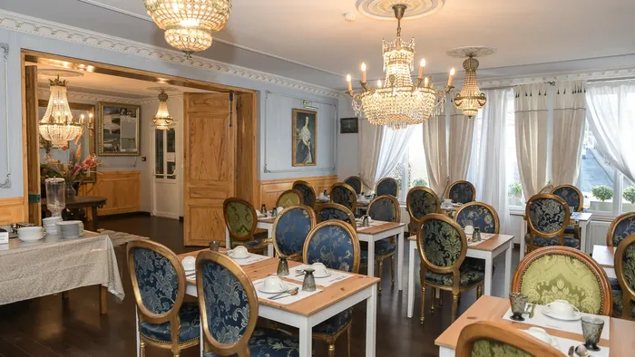 Salle à manger élégante avec des lustres et des chaises décorées à l'Hôtel Villa Aultia.