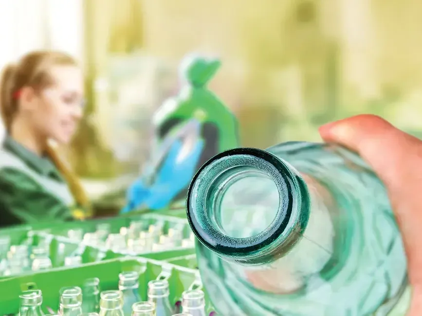 A person is seen holding a water bottle in front of a table - Lexis Hotel Group