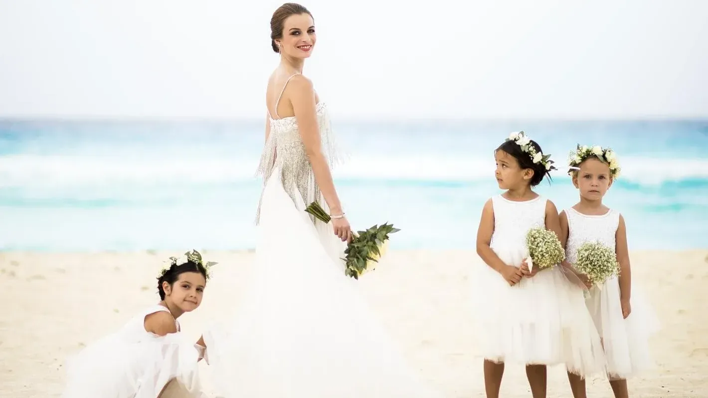 Bride & flower girls on beach at Grand Fiesta Americana