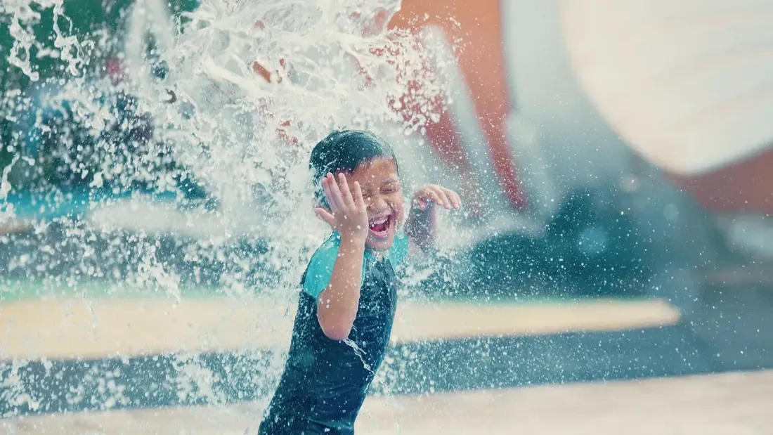 Child happily splashing in the water in the Sunway Lagoon waterpark at Sunway Velocity Hotel