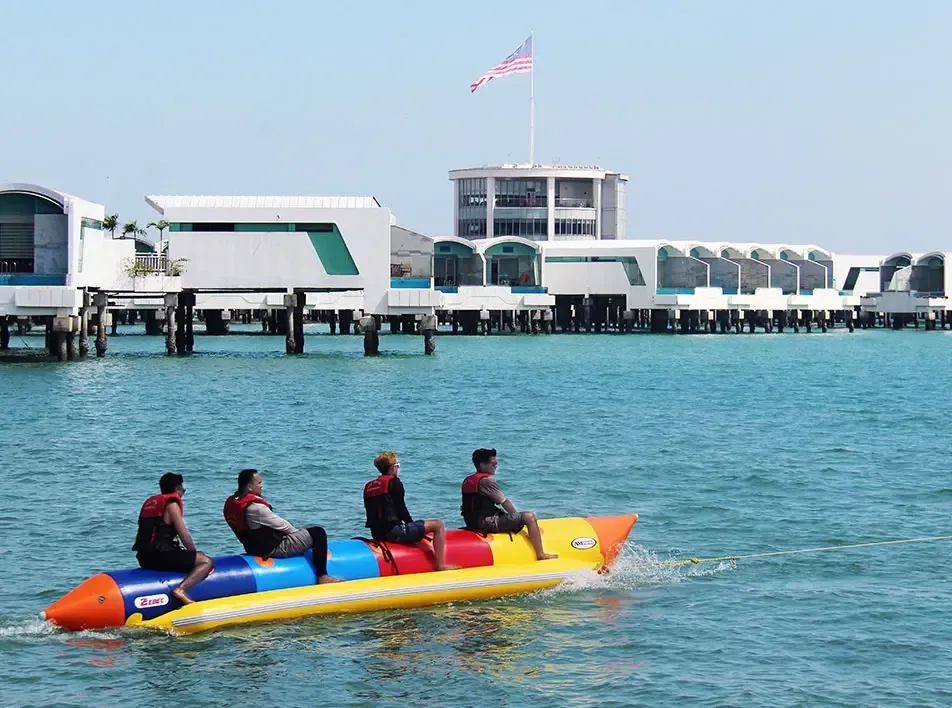 Group of four riding colorful banana boat during water sports – Lexis Hibiscus Port Dickson