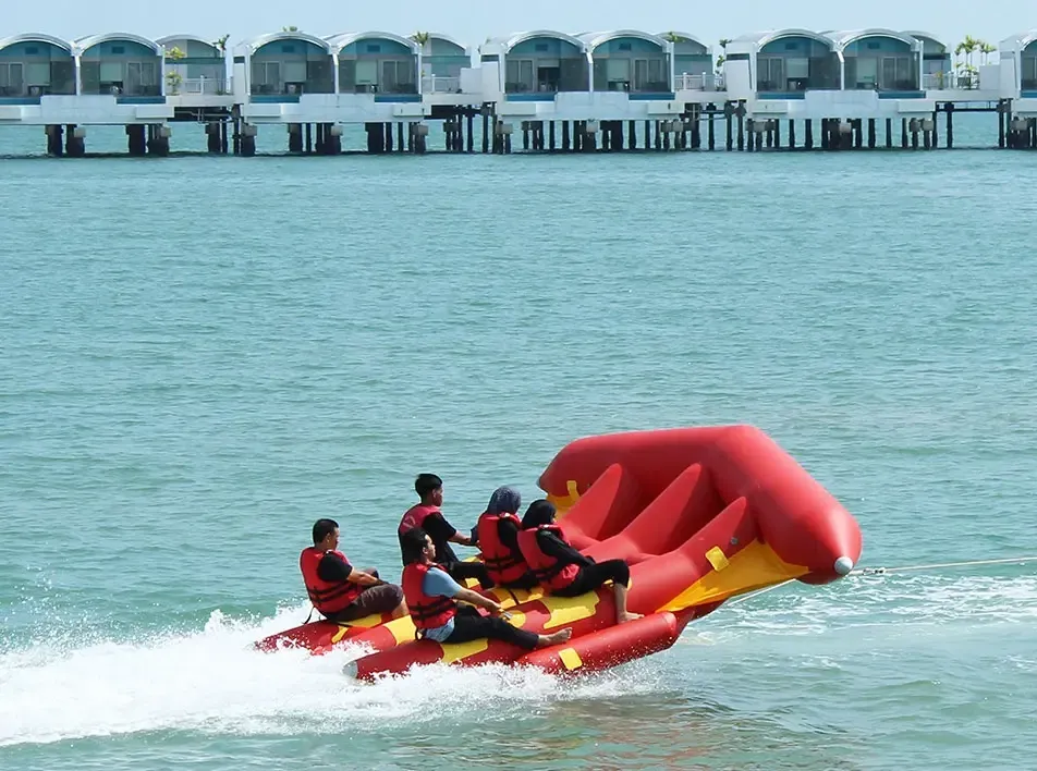 Tourists riding red inflatable banana boat across water – Lexis Hibiscus Port Dickson