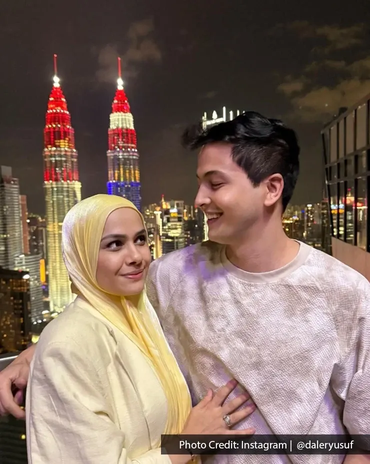 Happy couple posing in front of Petronas Twin Towers, capturing a memorable moment during their romantic getaway.