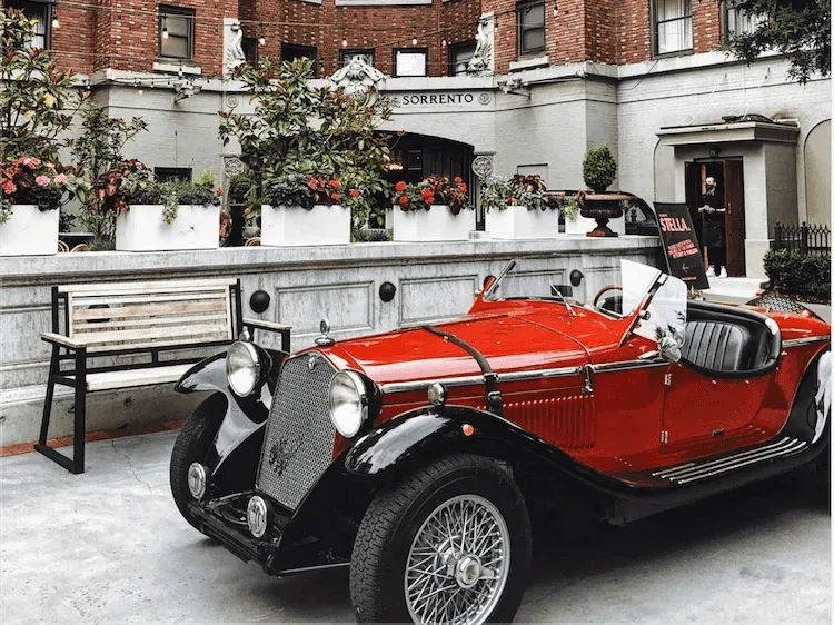 Vintage red and black convertible car parked outside Hotel Sorrento