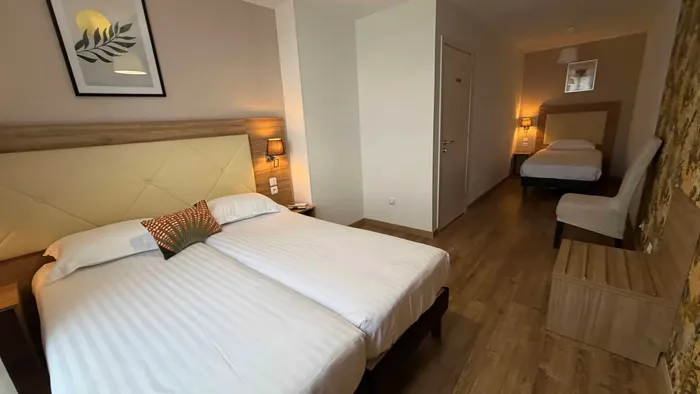 Chambre élégante avec deux lits jumeaux et décoration moderne au Grand Hôtel Molière.