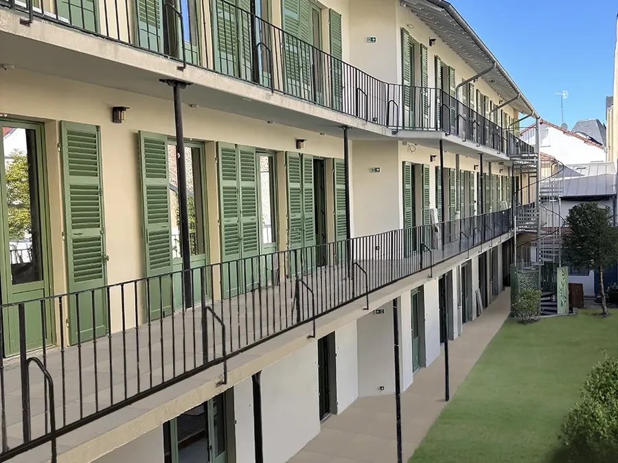 Façade avec balcons, volets verts et jardin intérieur au Flore Hôtel & Jardin