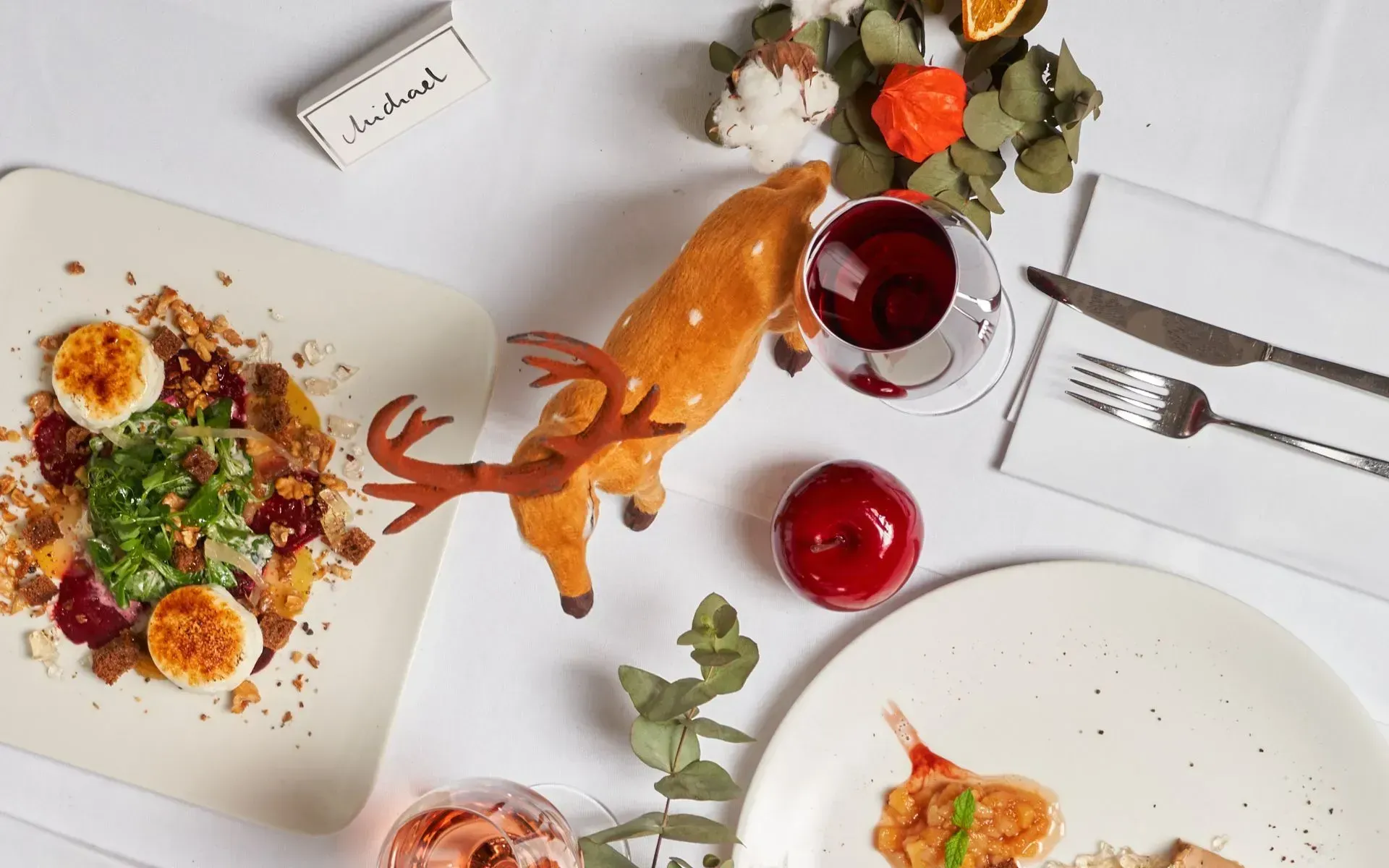 A dining table set with various plates of food and glasses of wine, ready for a meal at Flemings Hotels