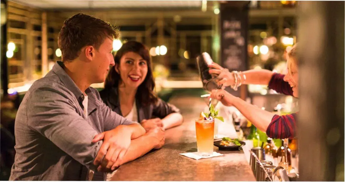 A couple enjoying a cocktail at the bar at Maybe Mae in Adelaide