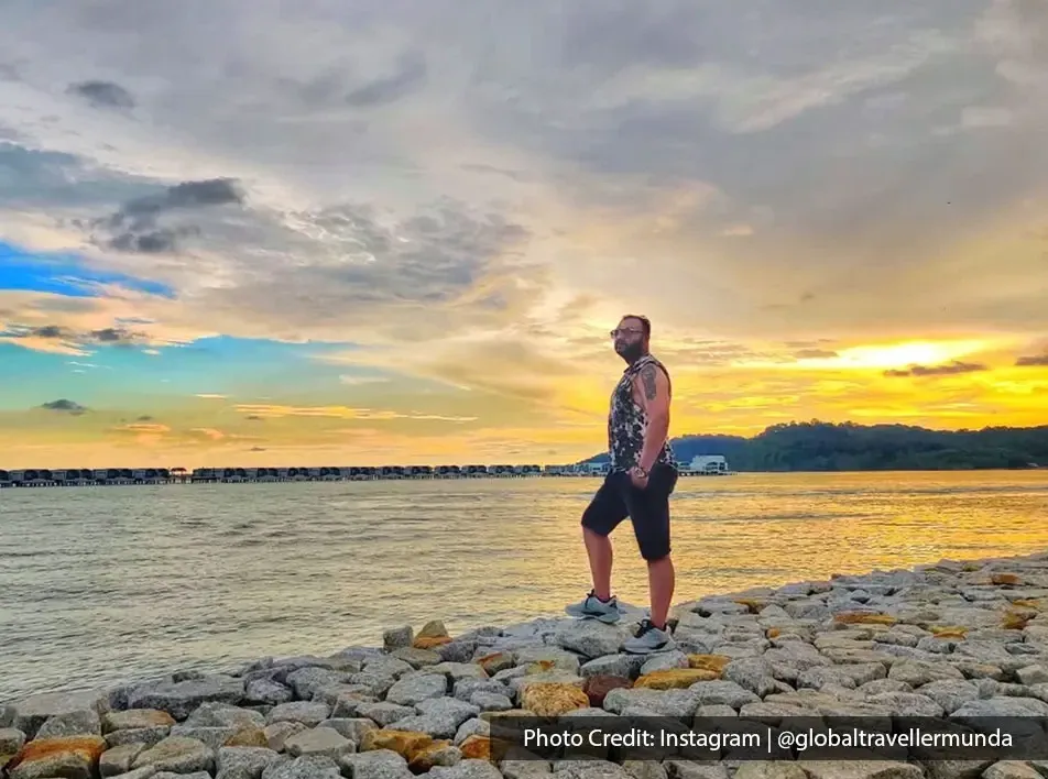 A man standing by the seashore in the evening - Lexis MY