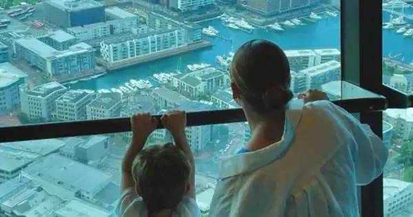 Mother and son looking out the SkyWalk window with view of city below