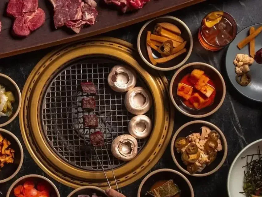 Korean BBQ grill at COTE Miami with meats and side dishes