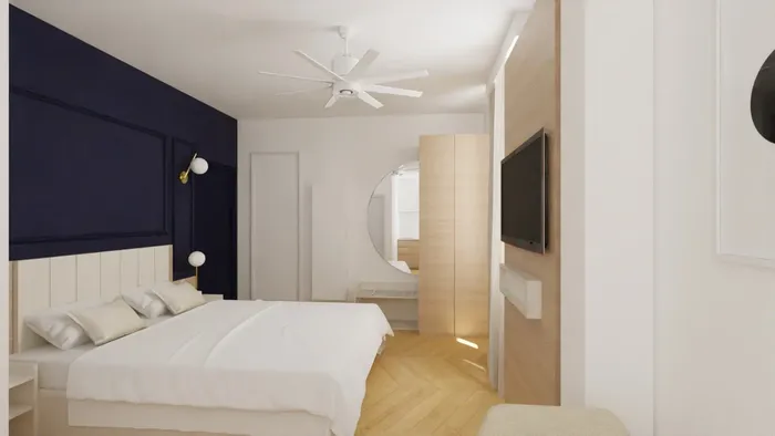 Chambre élégante avec lit blanc, ventilateur, miroir, et TV murale chez Les Sources Callou.