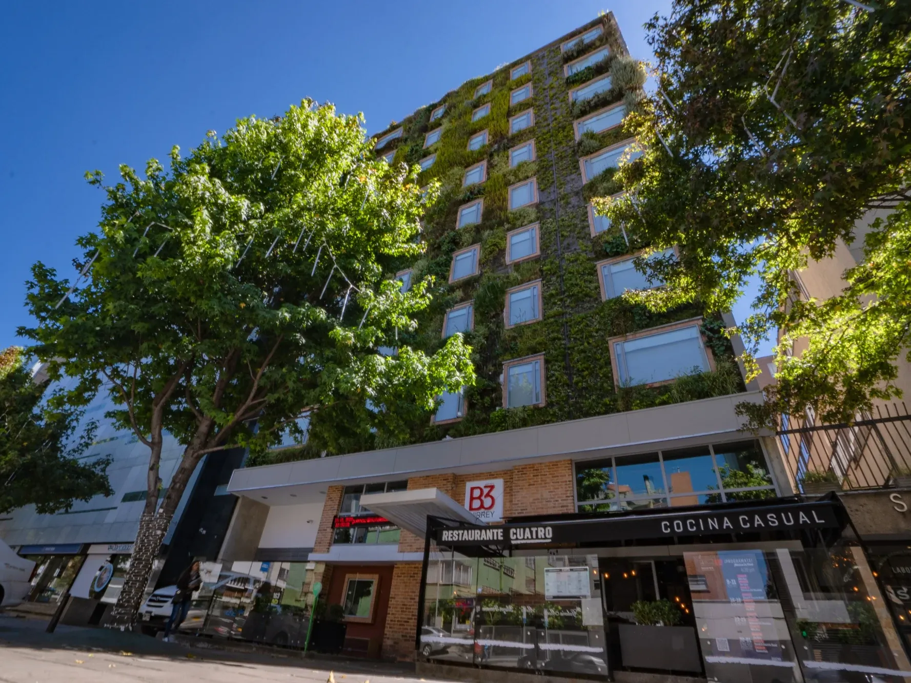 Vista exterior de Hotel B3 Virrey con muro vegetal vivo en la fachada superior, hotel destacado en Bogotá, Colombia