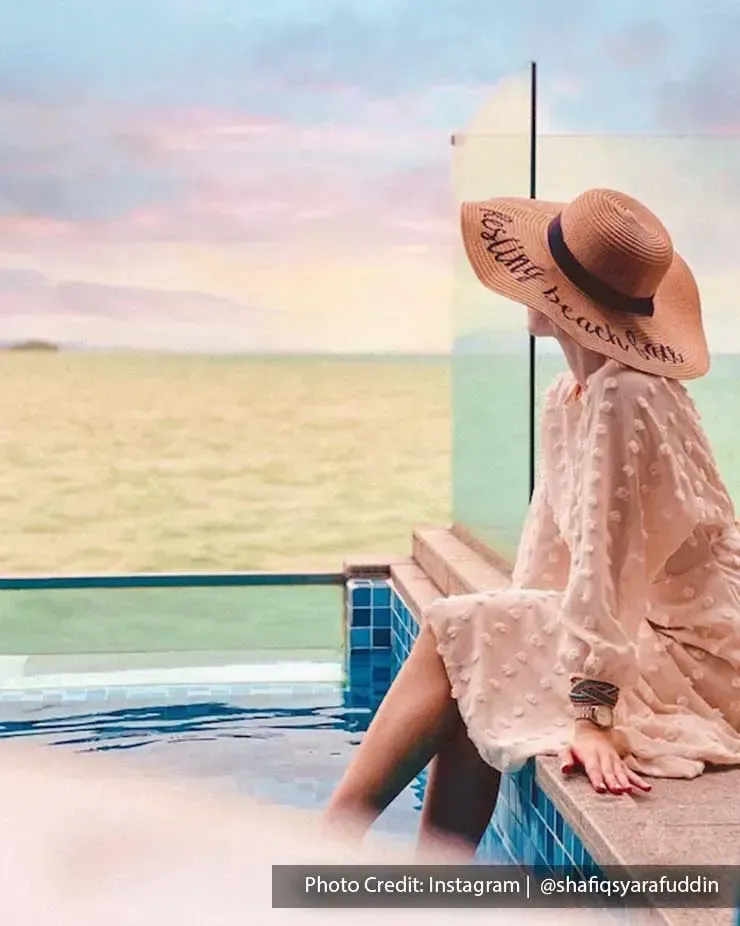 Woman sitting next to a pool at Lexis Hibiscus
