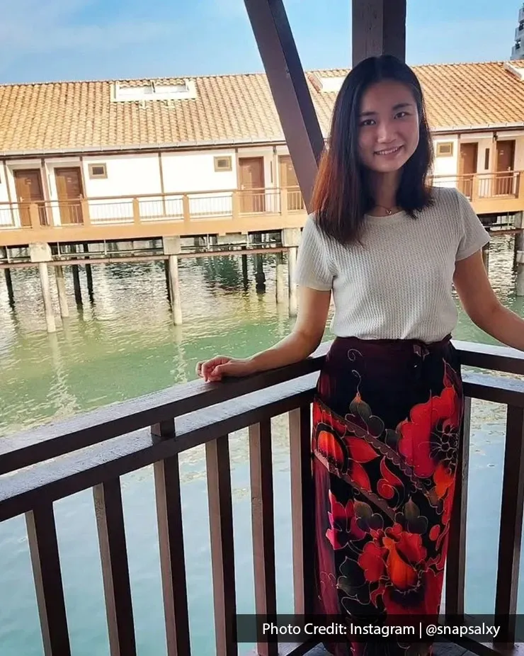 Woman standing on a balcony overlooking overwater chalets at Lexis Port Dickson.