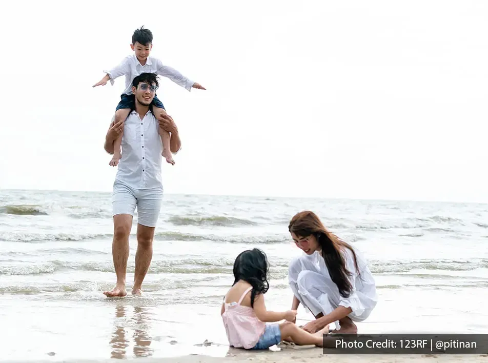 A family enjoying their beach vacation together by the beach - Lexis MY