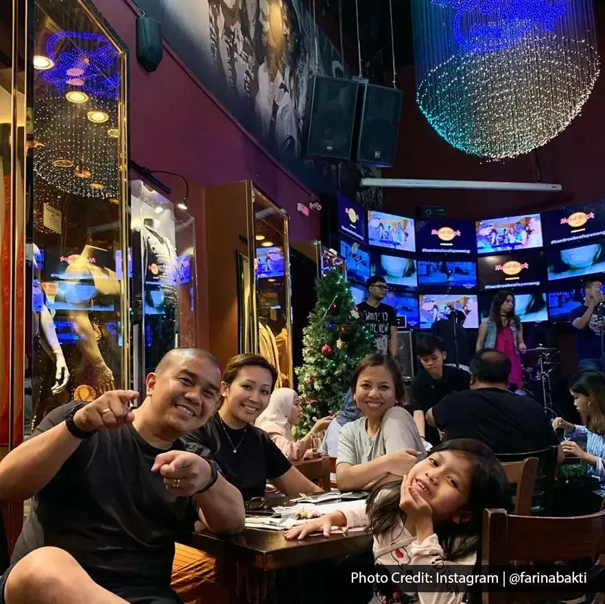 Group enjoying dinner with live music at Hard Rock Cafe Penang.