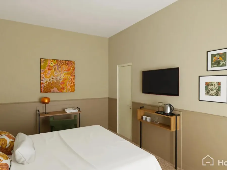 Chambre moderne avec lit double, télévision murale et œuvres d'art colorées au Flore Hôtel & Jardin