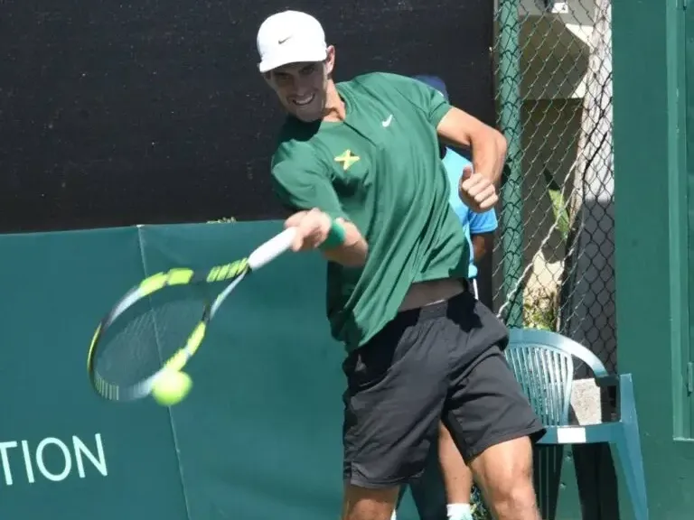 Male tennis player swinging racket showcasing exciting things to do in Kingston Jamaica near Jamaica Pegasus Hotel