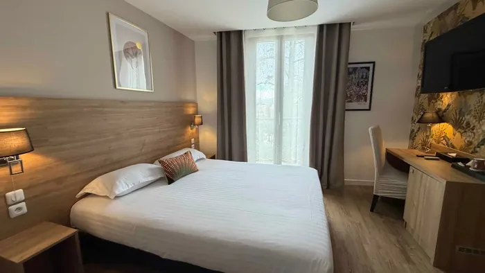 Chambre confortable avec lit double et bureau au Grand Hôtel Molière.