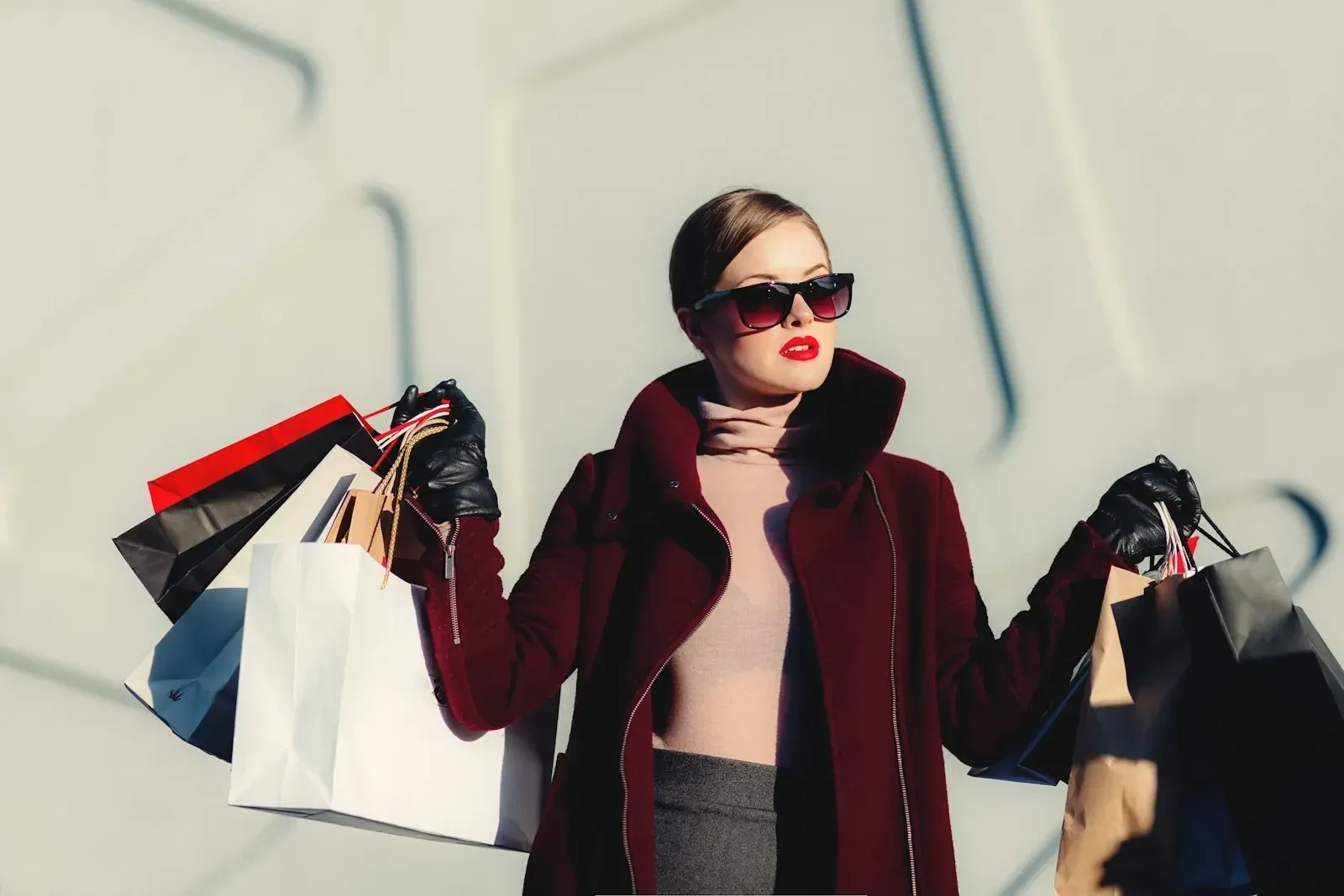 A shopper carrying an armful of boutique shopping bags