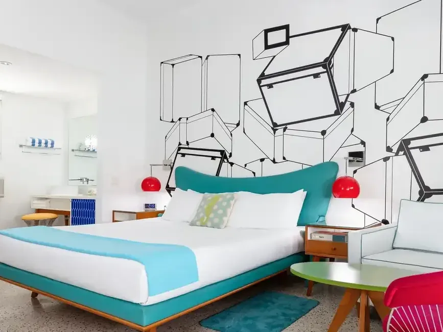 Electra Deluxe room at The Vagabond Hotel Miami with turquoise bed, mural wall, and colorful seating