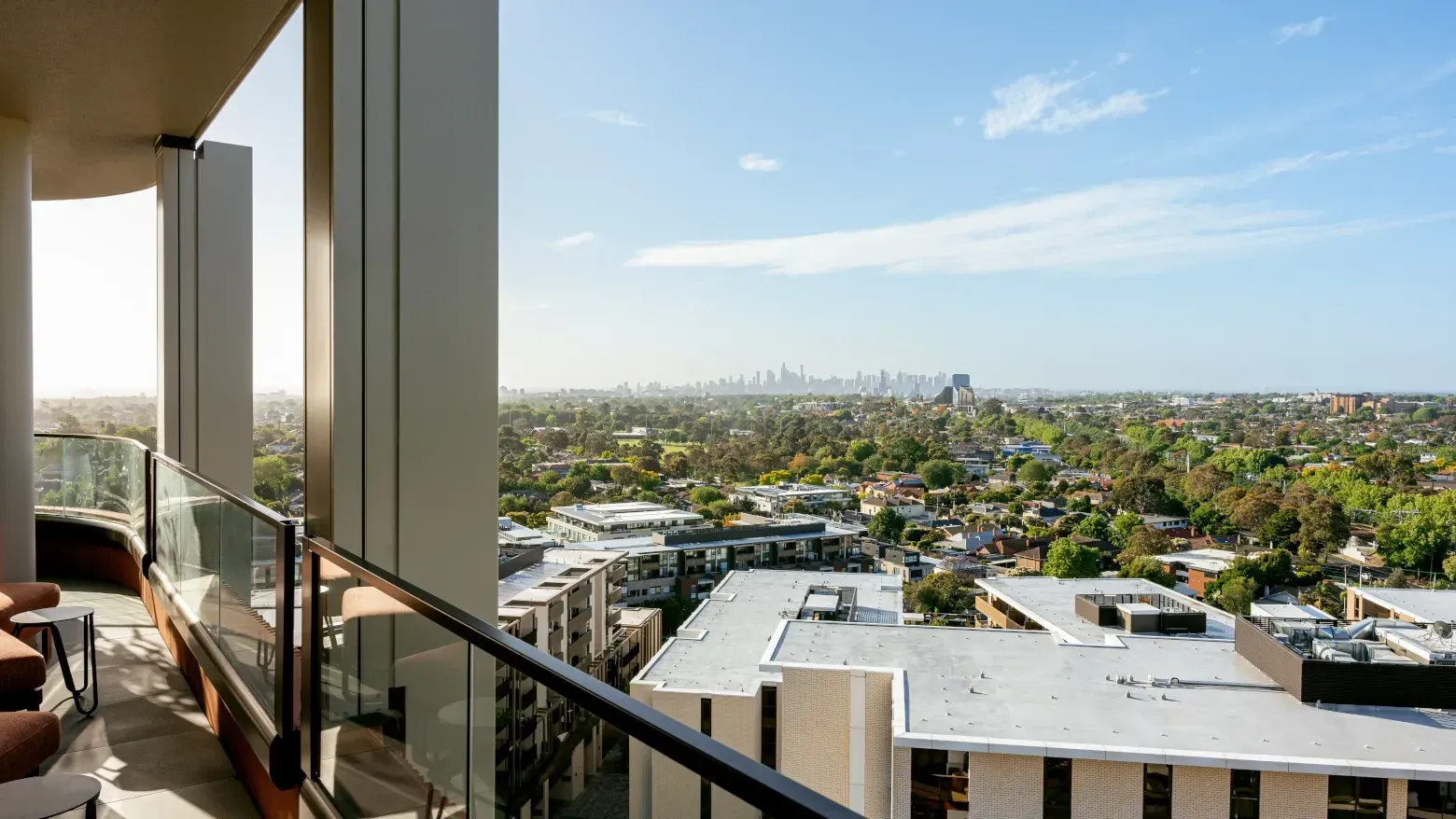 Caulfield Place balcony with city skyline and greenery view in the background.
