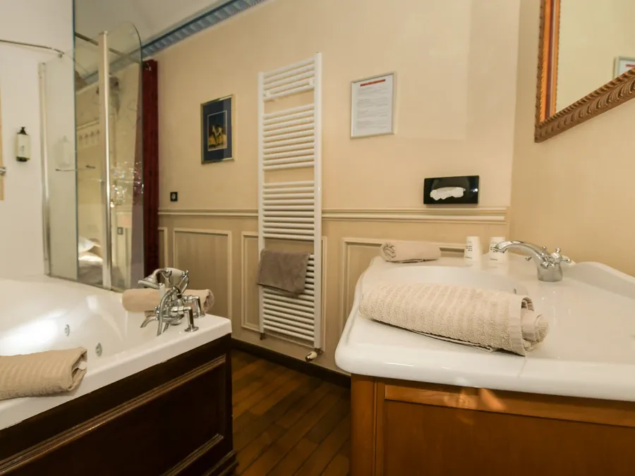 Salle de bain élégante avec baignoire et lavabo à l'Hôtel Villa Aultia à Ault.