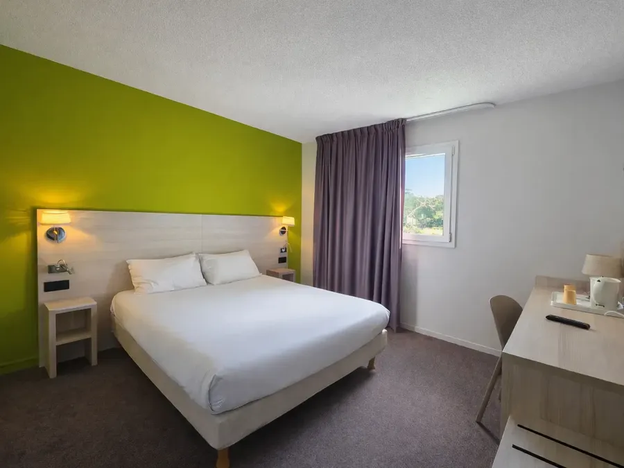 Chambre double confortable avec lit, bureau et télévision à Hotel Les Bruyères, Castets.