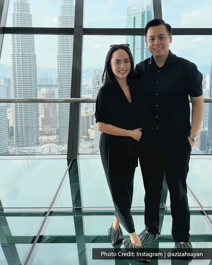 A man and woman on a glass floor with a stunning view of the Kuala Lumpur skyline 