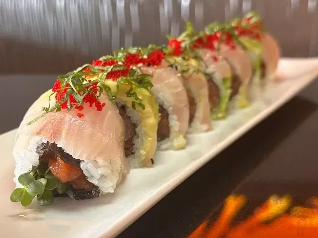 Sushi roll with tuna, avocado, and roe on a white plate served in Miso Phat Sushi at Miso Phat Sushi