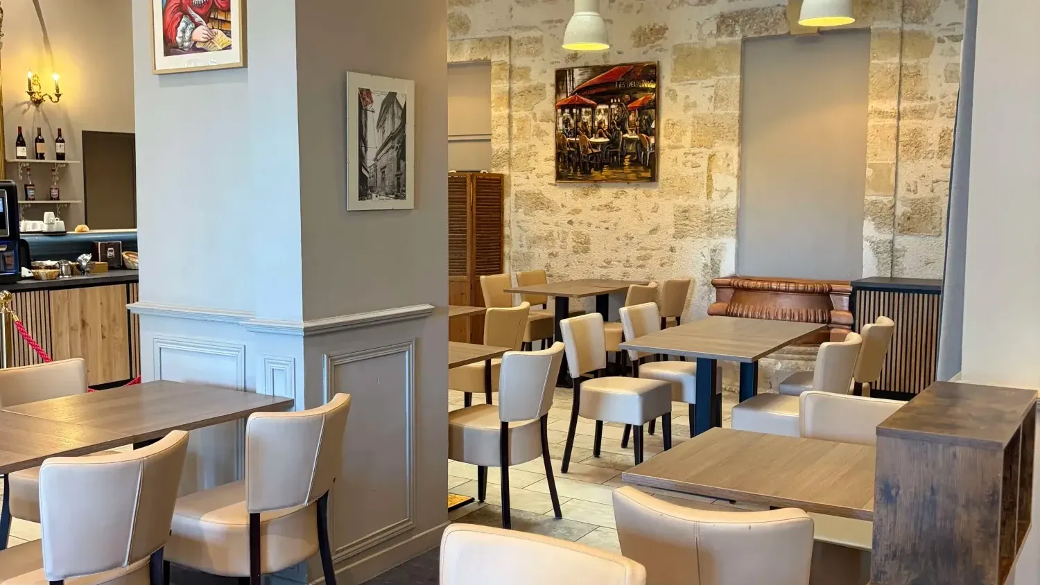 Restaurant élégant avec tables en bois et chaises blanches au Grand Hôtel Molière à Pézenas.