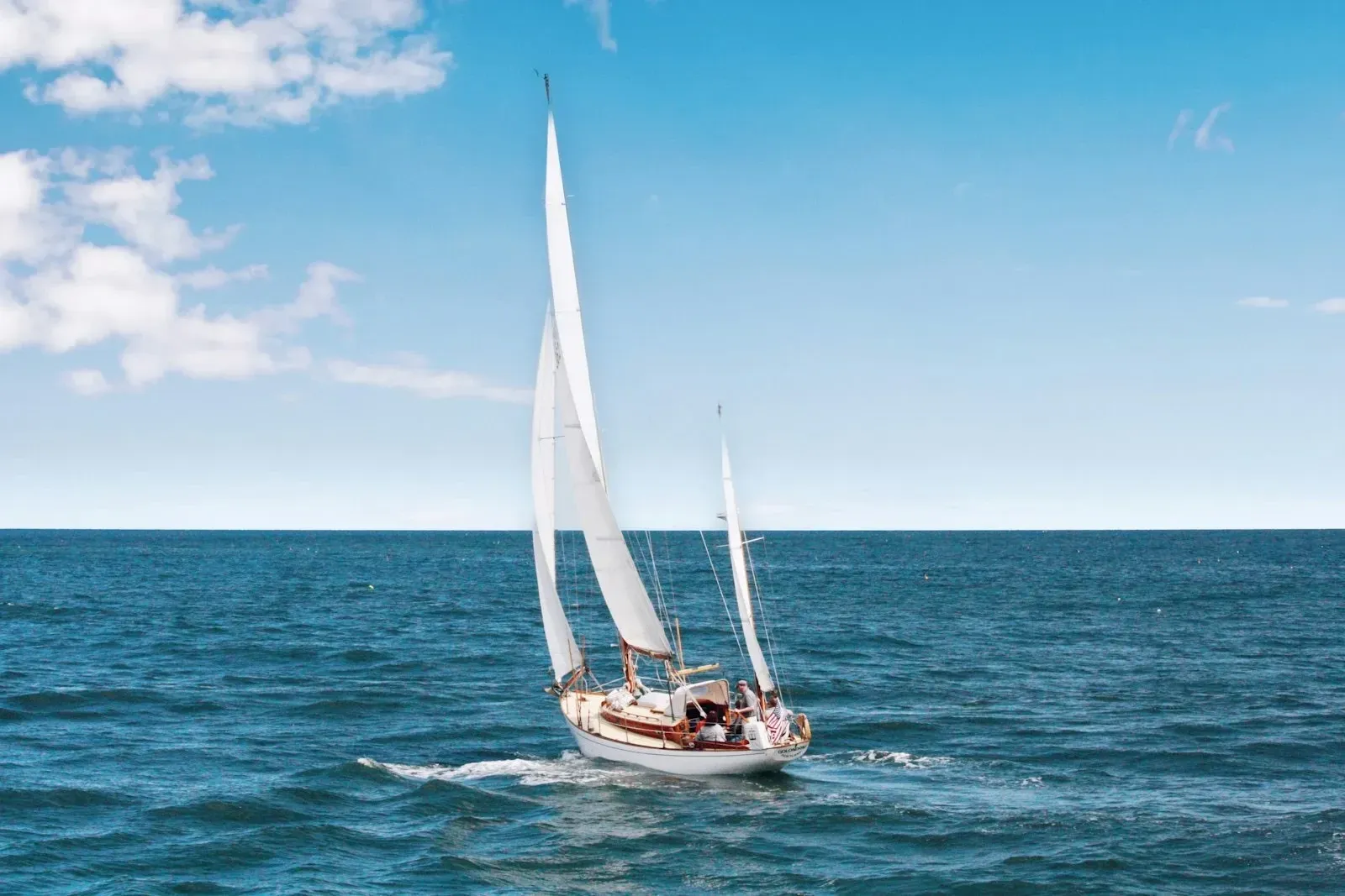 A sailboat under full sail on open blue water