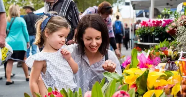 A mother and daughter looking at flowers at a Hobart market