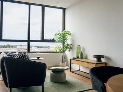 Living room with modern furniture and large windows at Caulfield Place.